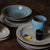 stacked tableware in mixture of blue, black and sand